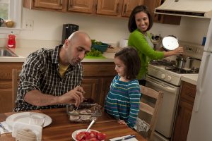 Image of father and daughter using a meat thermometer.