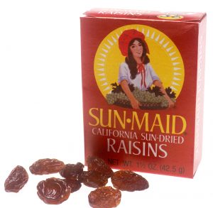 A red box of raisins with a few individual raisins