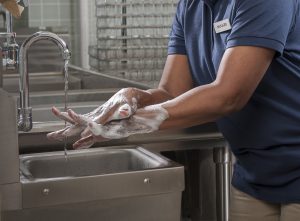 Person washing hands with soap at a sink