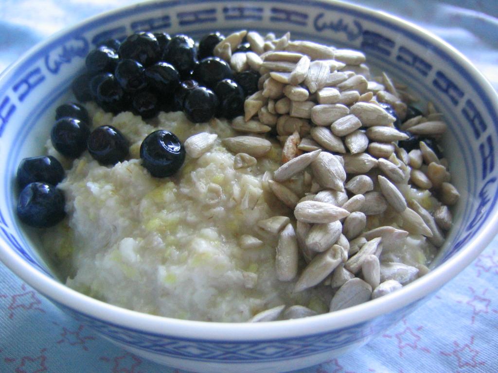 An example of a fiber packed meal. A bowl of oatmeal topped with blueberries and sunflower seeds.